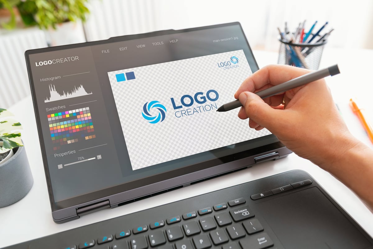 Logo design in progress on a creative workstation with digital tools and color references